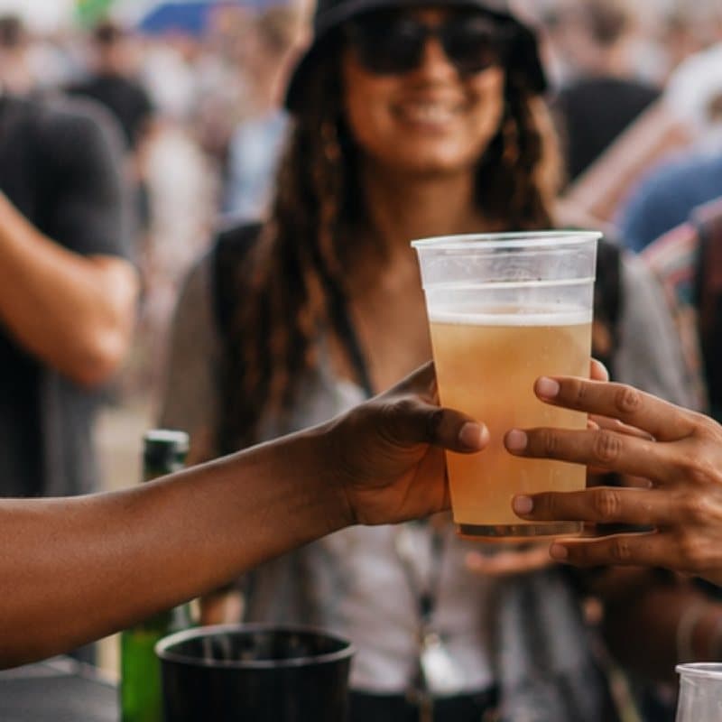 A cold beer handed over the bar at a festival